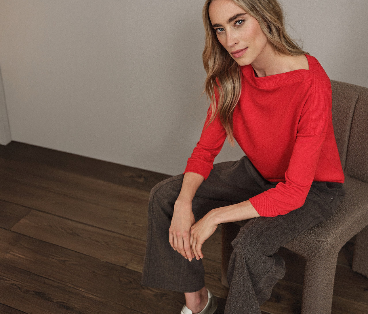 Frau sitzt auf einem Stuhl und trägt ein rotes Street One T-Shirt mit Rippdetail.