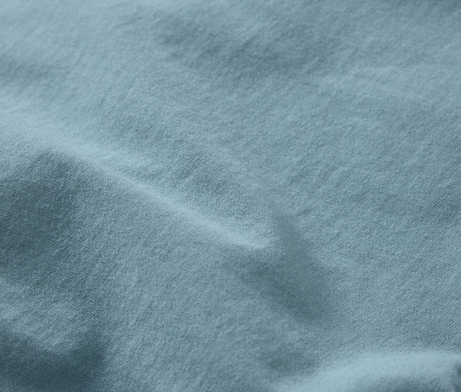 Nahaufnahme eines hellblauen Stoffes mit feiner Textur und Falten.