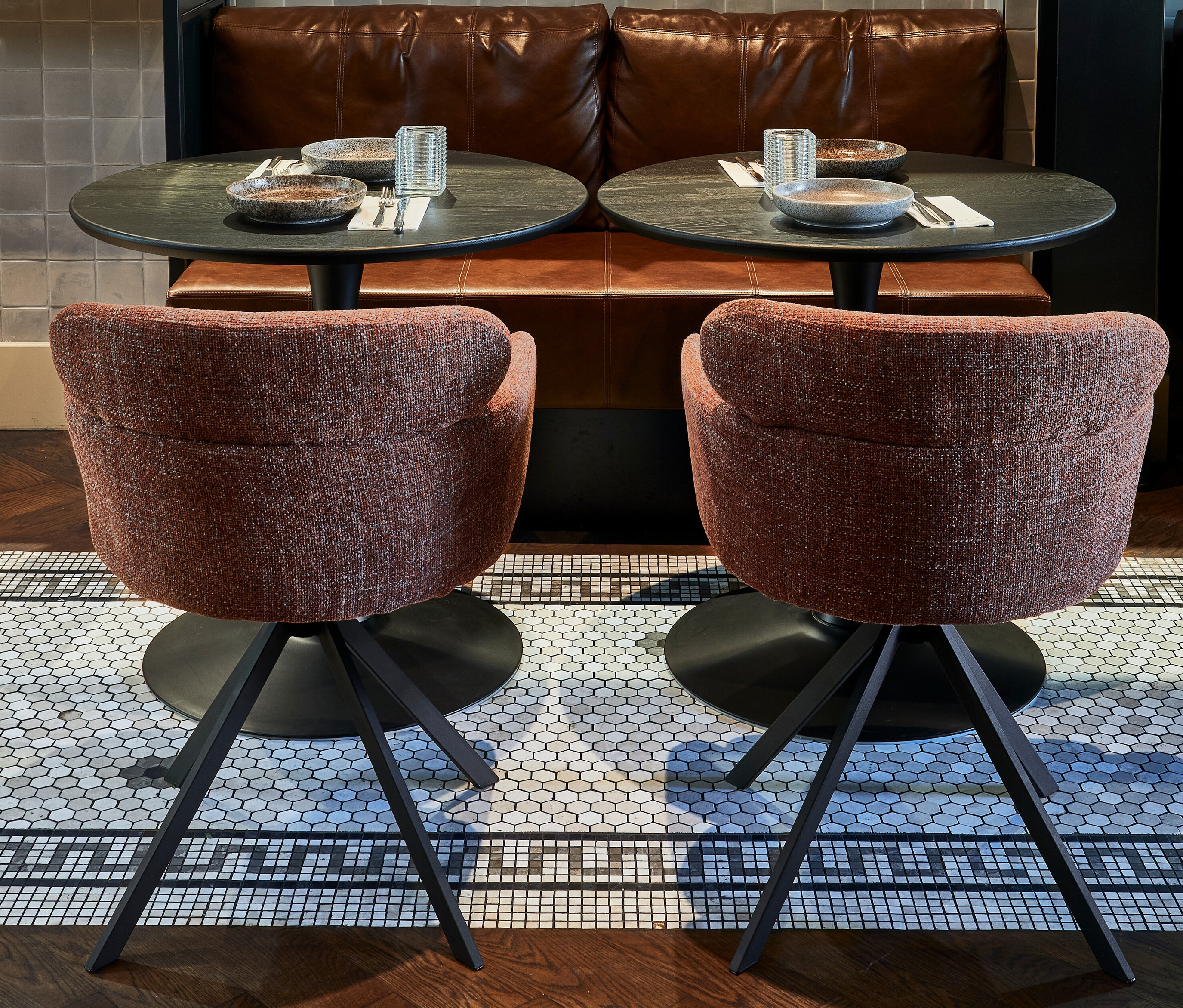 Zwei Woood Stühle »Fenne« (2er-Set, chestnut) vor Tischen mit Geschirr und Gläsern.