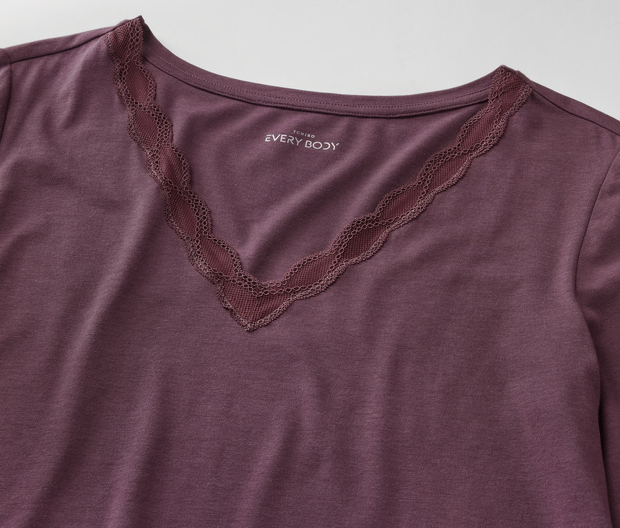 Violettes Langarmshirt mit V-Ausschnitt und Spitzenbesatz.