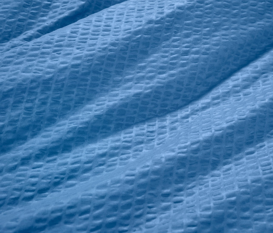 Nahaufnahme von blauer Seersucker-Bettwäsche.