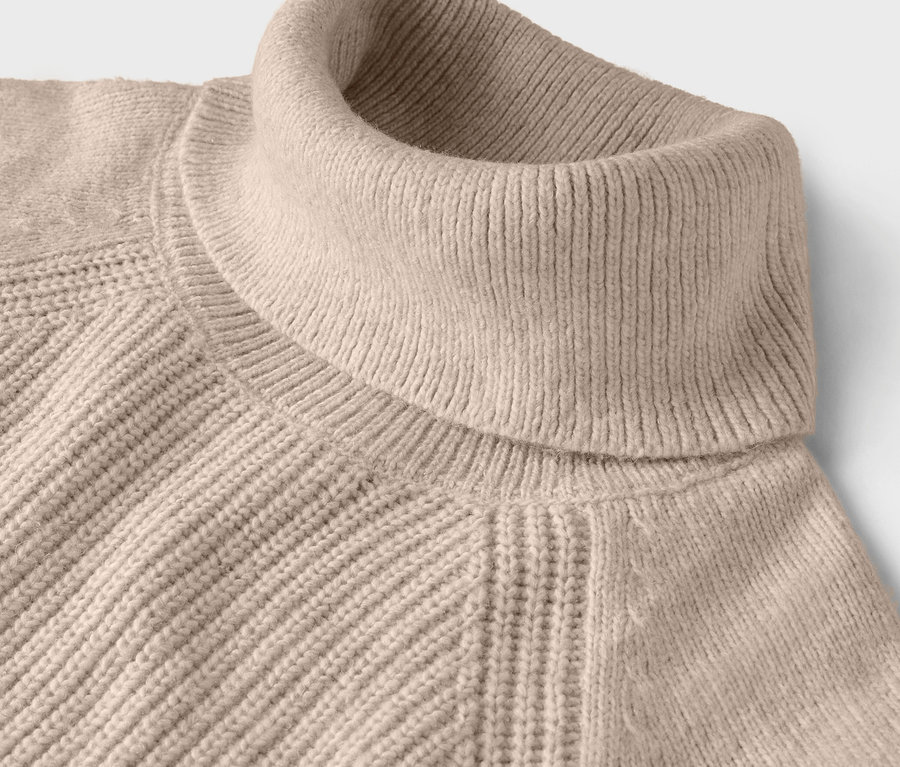 Detailansicht eines beigen Rollkragenpullovers mit Rippstrickmuster.