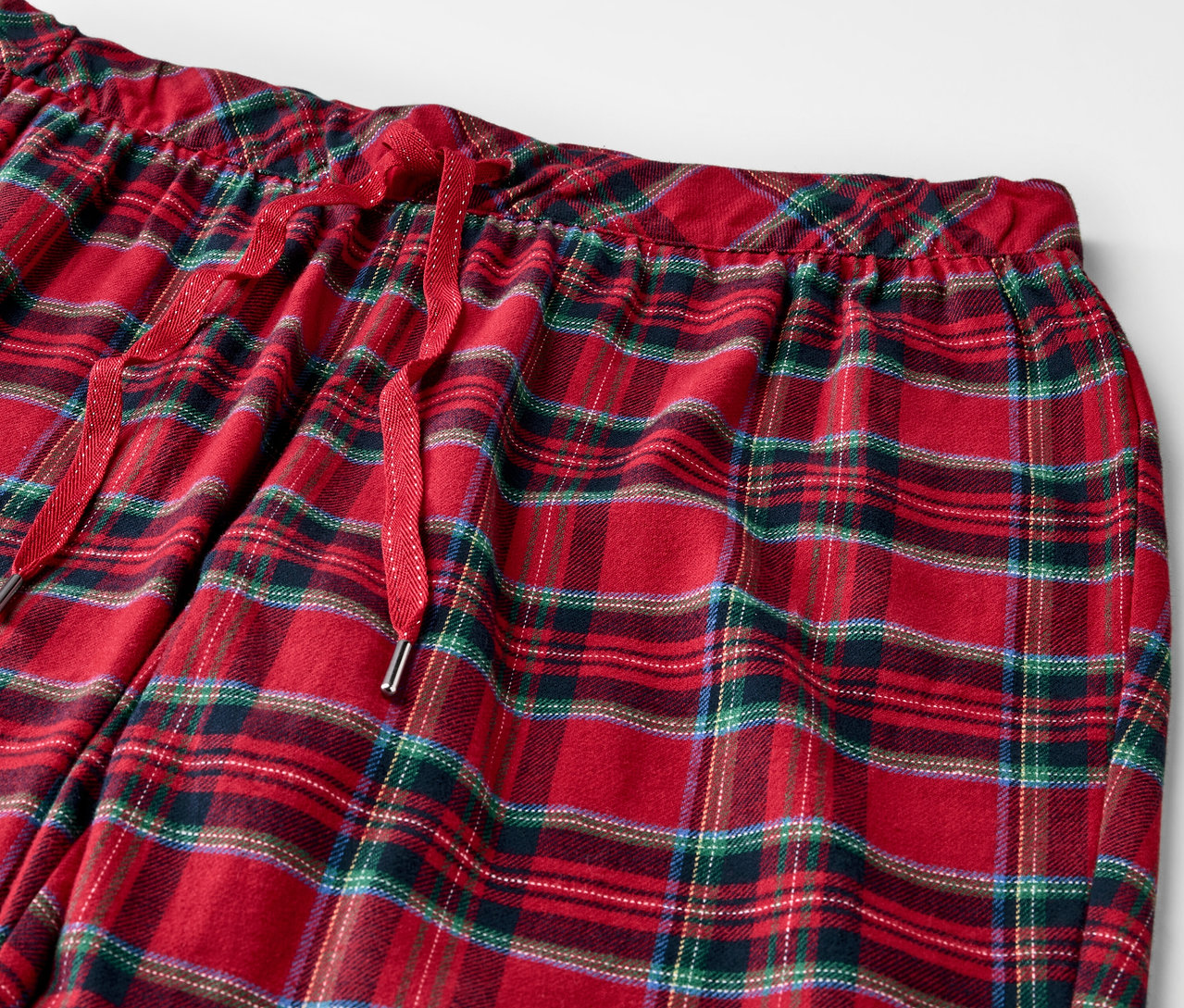Detail einer rot karierten Pyjamahose mit Kordelzug in der Taille.