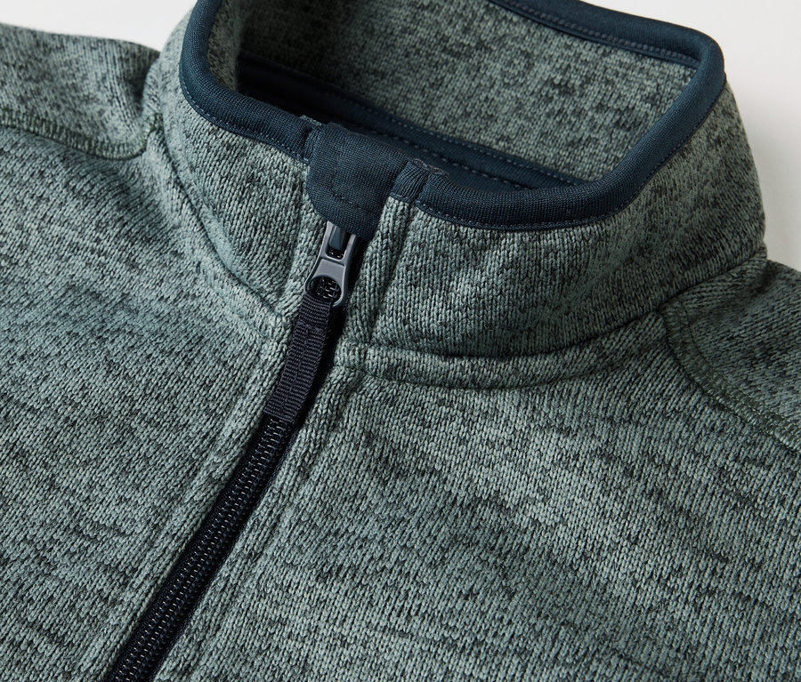 Detailansicht einer Kinder-Hybrid-Strickfleecejacke mit Reißverschluss.
