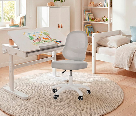 Kinderzimmer mit weißem Schreibtisch mit Zeichnung, Stuhl und Bett vor Bücherregal und Schrank.