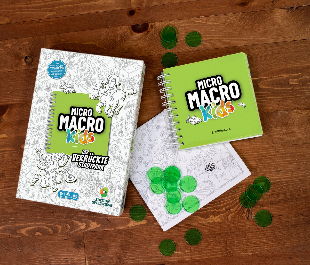 Auf einem Holztisch liegt das Spiel MicroMacro Kids »Der verrückte Stadtpark« mit Lupe und Ermittlerbuch.