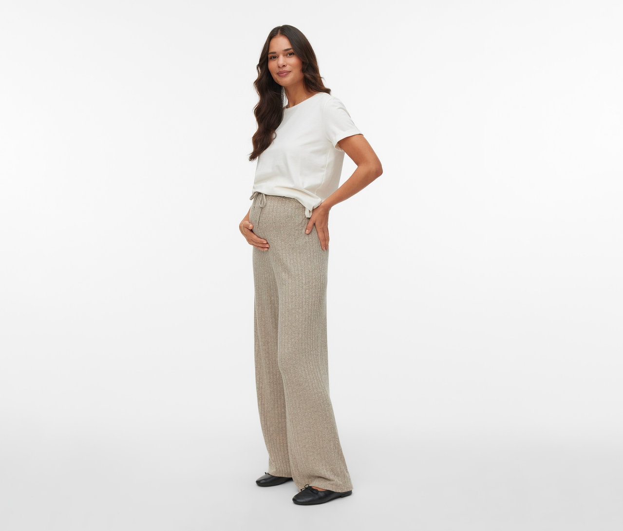 Frau posiert in MAMALICIOUS Loosefit Hose »MLPAMMIE« und weißem T-Shirt, Hand auf dem Bauch.