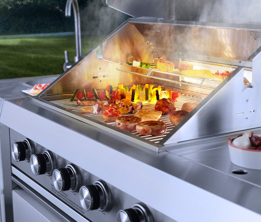 Auf einem Buschbeck Outdoorküche »Oxford« Grill liegen Gemüsespieße, Würstchen und Fleisch.