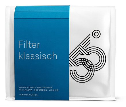 Eine Packung Filter Klassisch Kaffee mit blauem Etikett und weißer Verpackung mit schwarzem Logo.