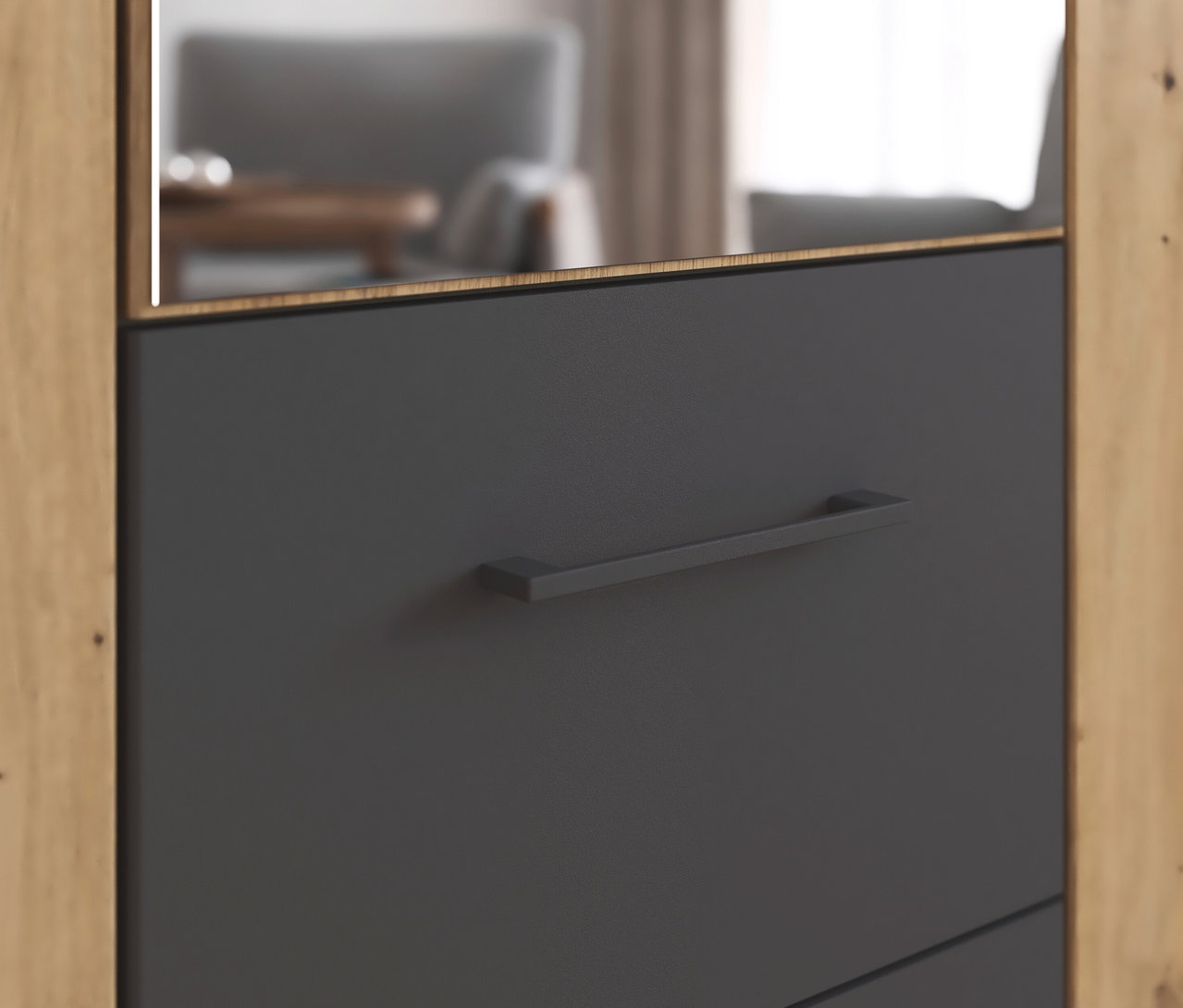 Detailansicht eines rauch Drehtürenschranks »Butte« mit drei Türen. Der Schrank hat eine graue Tür mit einem länglichen, dunklen Griff und einem Rahmen in Holzoptik.