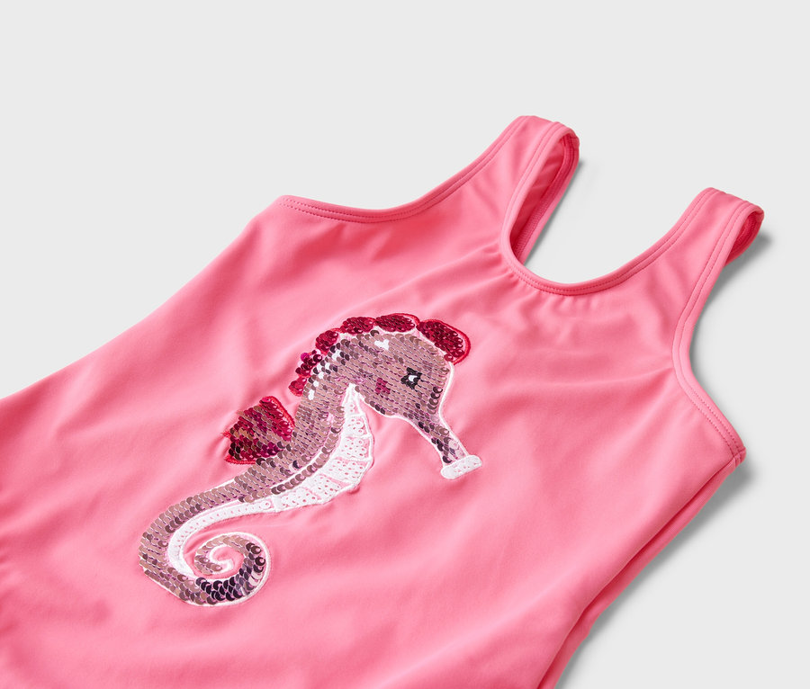 Nahaufnahme eines rosafarbenen Badeanzugs mit einem Pailletten-Seepferdchen-Design.