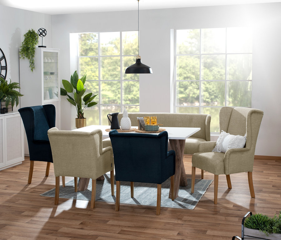 Esszimmer mit weißem Tisch, Stühlen und beige »Hendrick« Polsterbank vor Fenster.