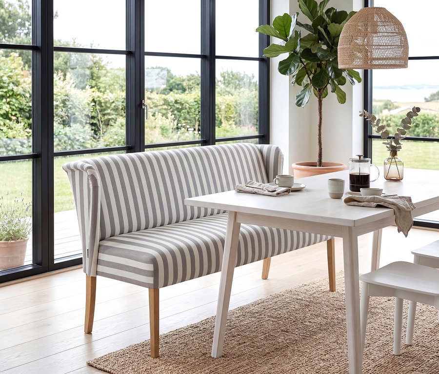 Gestreifte »Hendrick« Polsterbank steht am Esstisch mit Kaffeegeschirr vor Fenster mit Gartenblick.