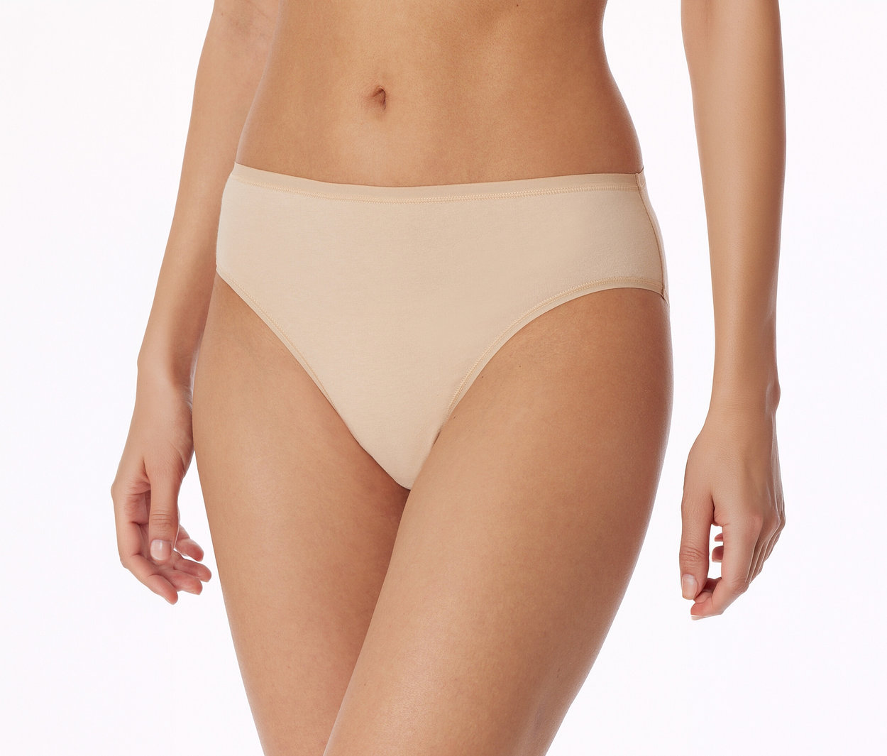 Nahaufnahme einer Person, die hellbeige Slips mit einem dünnen Gummibund trägt, vor weißem Hintergrund stehend.