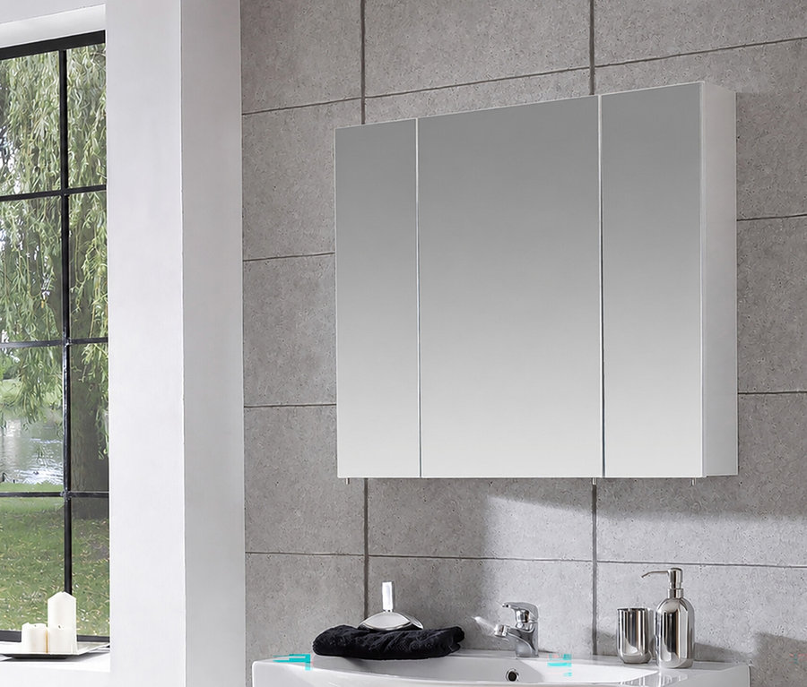 Weißer Spiegelschrank »Basic«, 80 cm breit, mit drei Spiegeltüren über einem Waschbecken in einem Badezimmer mit Fensterblick ins Grüne.