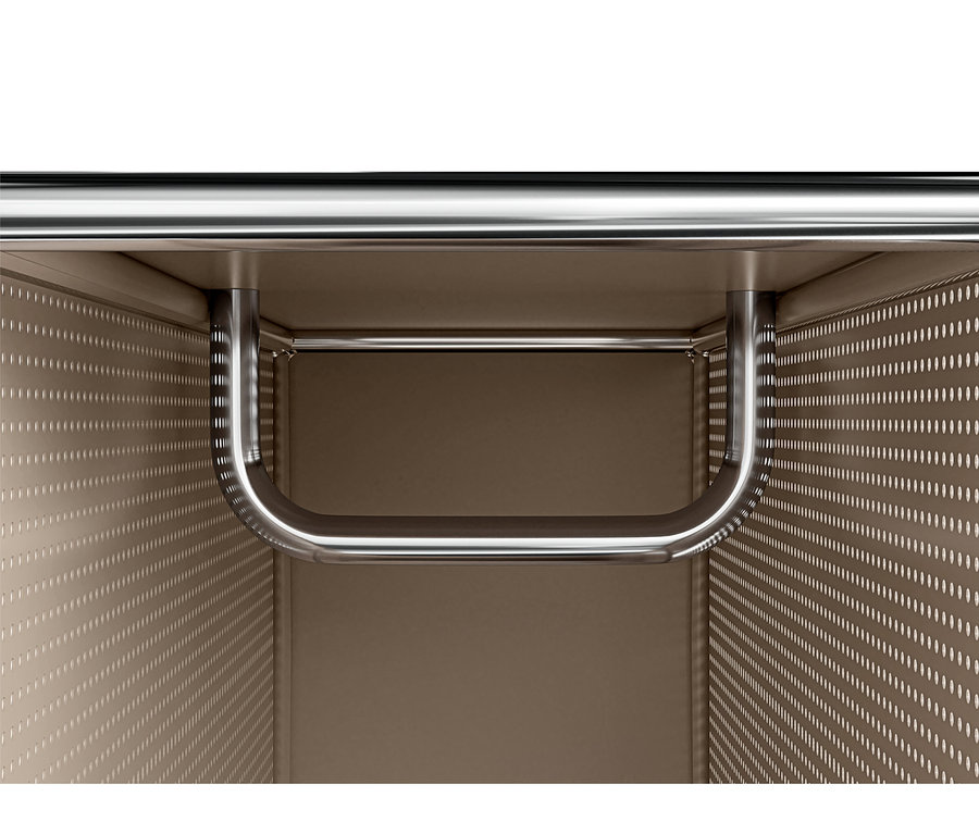 Nahaufnahme des Innenraums eines beigen perforierten Schranks mit einem glänzenden U-förmigen Metallgriff, der oben und seitlich befestigt ist, und einer horizontalen Metallstange darüber.
