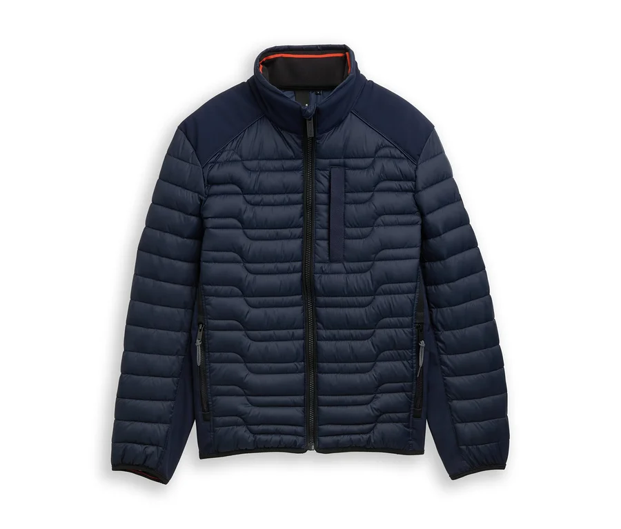 Dunkelblaue Steppjacke mit wellenförmigem Steppmuster am Körper, glattem Stoff an Schultern und Seiten, Stehkragen mit orangefarbenem Futter, durchgehendem schwarzem Reißverschluss und seitlichen Reißverschlusstaschen, flach auf weißem Hintergrund liegend.
