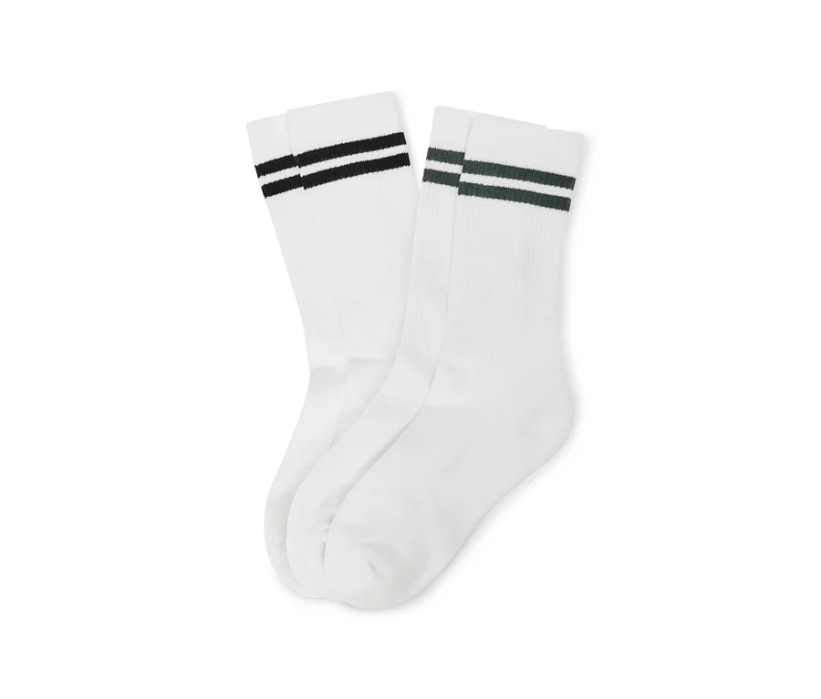 Zwei Paar weiße Socken, eines mit schwarzen und eines mit dunkelgrünen Streifen, nebeneinander liegend.