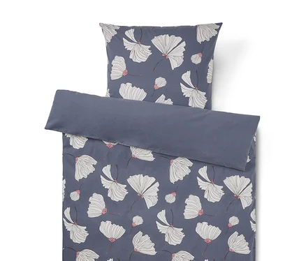 Bettwäsche-Set mit dunkelblauem Hintergrund und weißen Blüten mit rosa Akzenten. Der Kissenbezug liegt über dem Bettbezug, dessen obere Kante umgeschlagen ist und eine einfarbige dunkelblaue Rückseite zeigt.