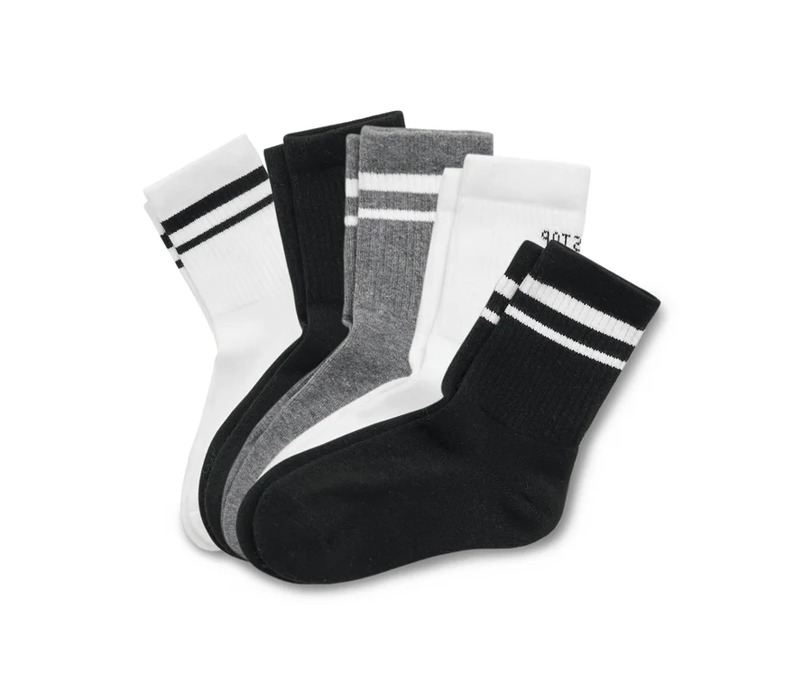 Mehrere Socken in Weiß, Grau und Schwarz sind gestapelt.