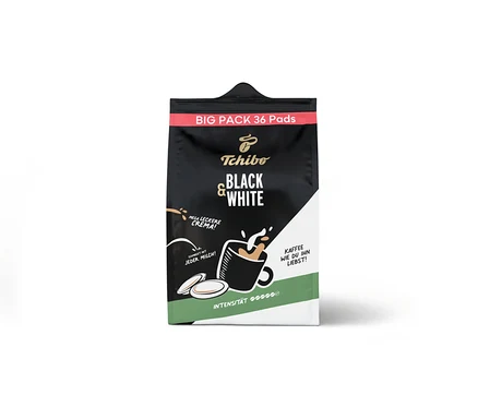 Schwarze und weiße Tchibo BLACK & WHITE Pads - 36 Pads Packung mit rotem oberen Band, weißer Seite und grünem Boden. Die Packung zeigt eine Grafik einer Kaffeetasse mit spritzendem Kaffee und Milch, zwei Kaffeepads und Texte.