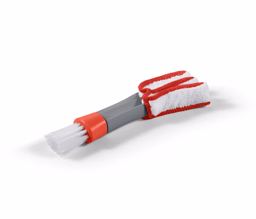 Eine 2-in-1-Reinigungsbürste mit weißen Borsten, einem grauen Griff und einem rot-weißen Lamellenreinigungsaufsatz.