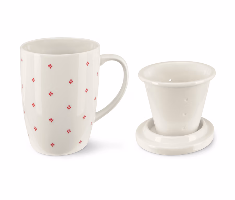 Eine Teetasse mit Sieb und Deckel. Die Tasse ist weiß und hat ein rotes Muster.