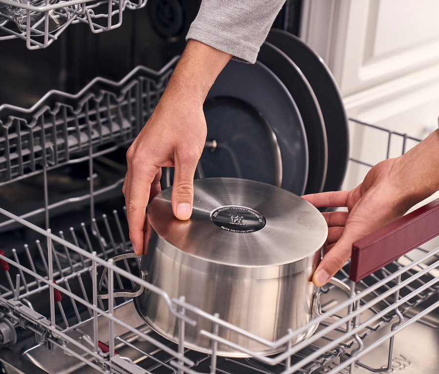 Hände stellen einen Topf aus dem Henckels by ZWILLING »Pulse« Kochgeschirrset in den Geschirrspüler.