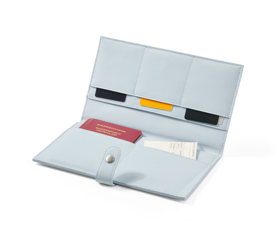 Geöffneter, hellblauer Reise-Organizer mit Reisepass, Karten und Ticket im Inneren.