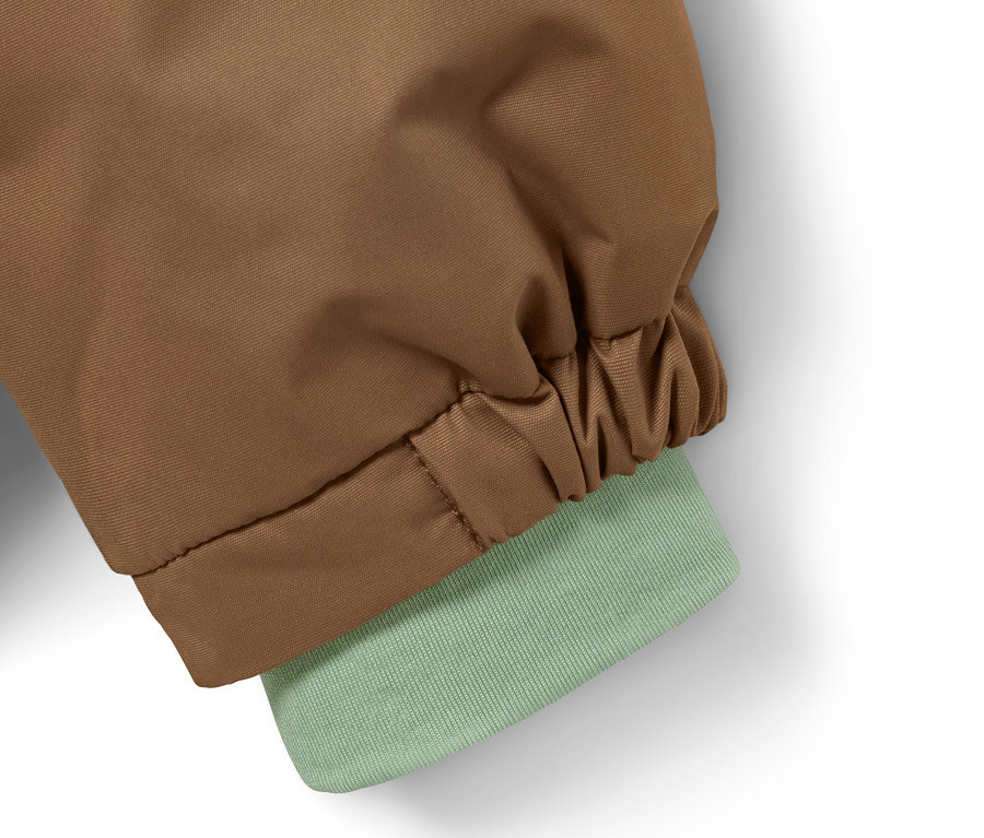 Detail einer braun-grünen Thermo-Regenjacke.