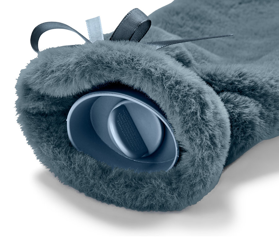 Detailaufnahme einer blauen Schlauch-Wärmflasche mit Plüschbezug und Schleife.