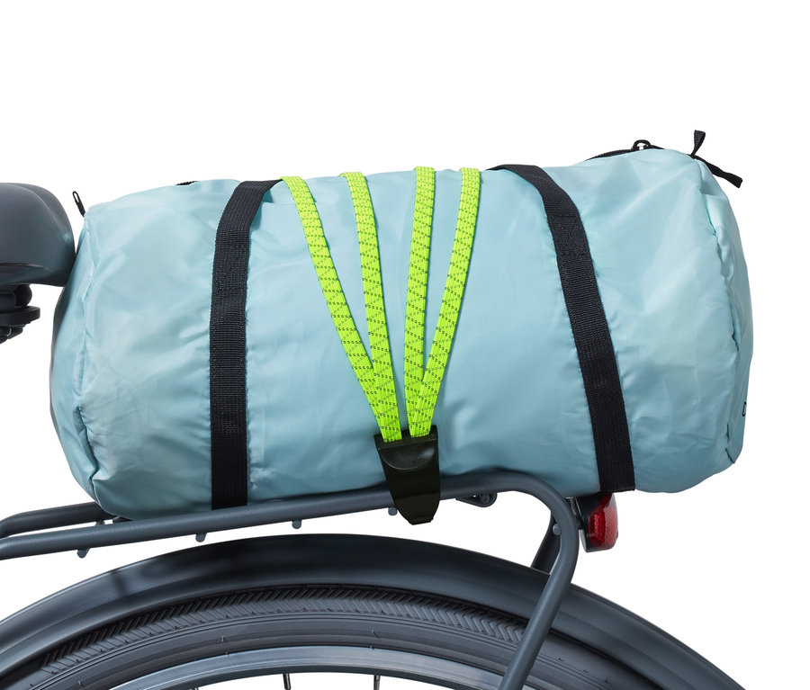 Hellblaue Tasche mit Fahrrad-Spanngurt am Gepäckträger eines Fahrrads befestigt.