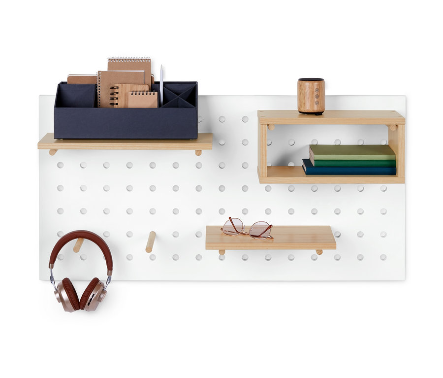 Weißes Wandpaneel mit Holzregalen, auf denen sich Gegenstände wie Kopfhörer, Brille, Bücher und Büromaterialien befinden.