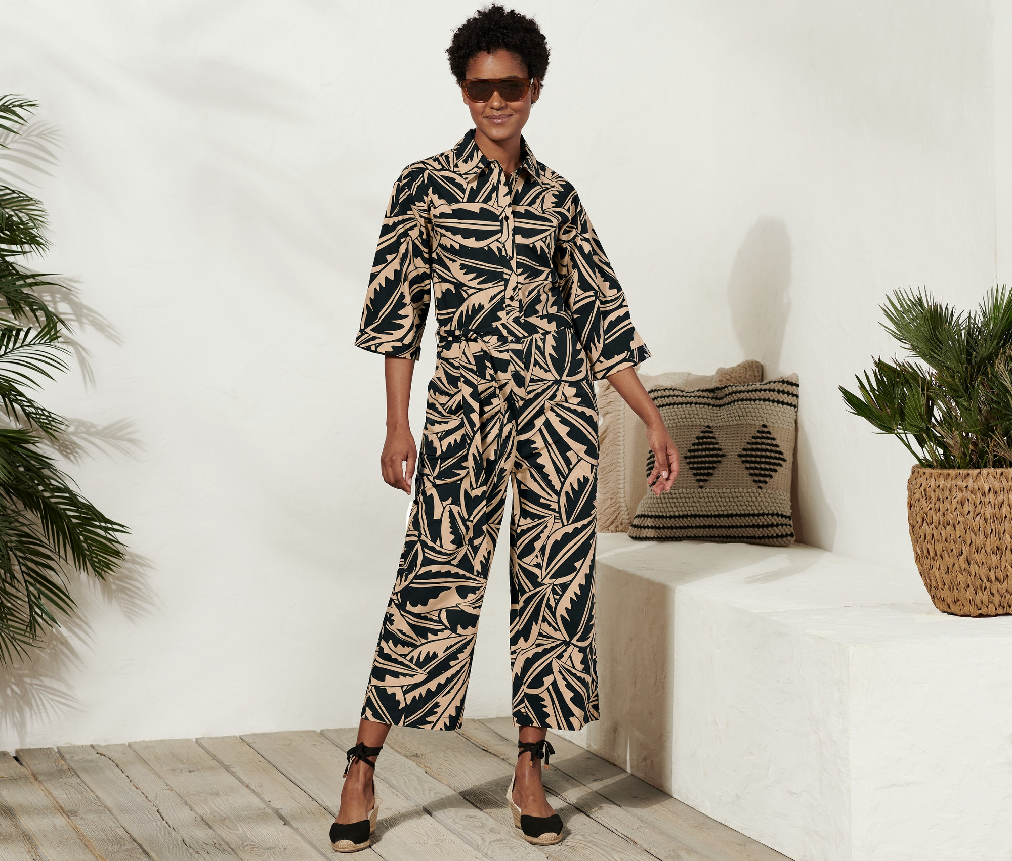 Frau posiert in einem Popeline-Overall mit Alloverprint.