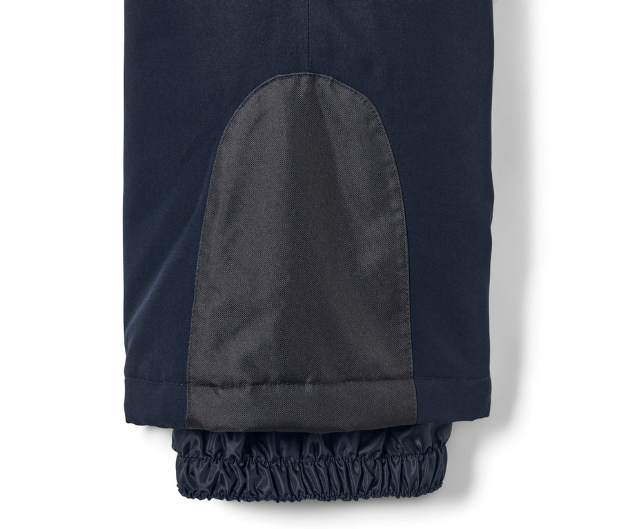 Detail einer dunkelblauen Skihose mit Flicken und elastischem Saum.