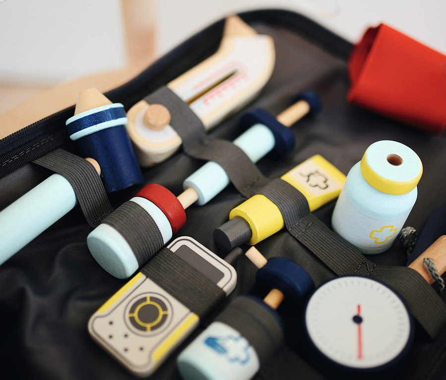 Offener small foot Notarzt-Rucksack mit hölzernen Spielzeug-Arztwerkzeugen und blauer Stoffmaske.