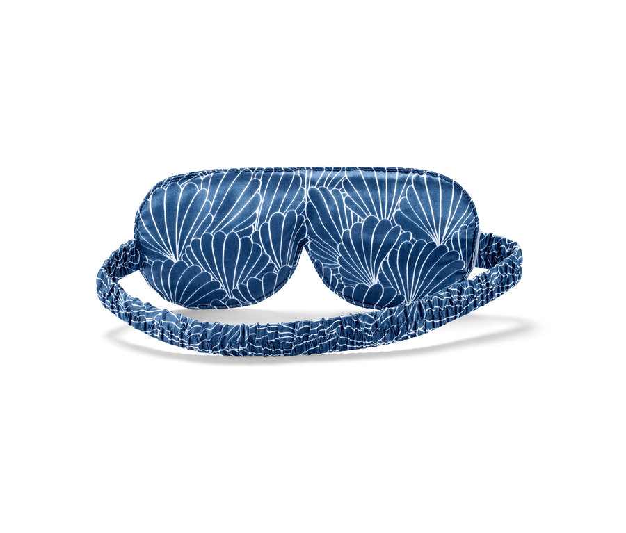 Eine blaue Seiden-Schlafmaske mit weißem Blumenmuster.