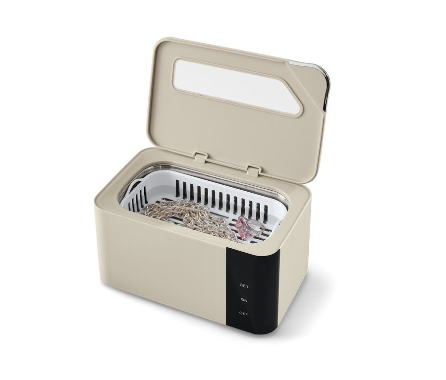 Ein geöffneter Ultraschallreiniger mit einer Kette und einem Ring darin.