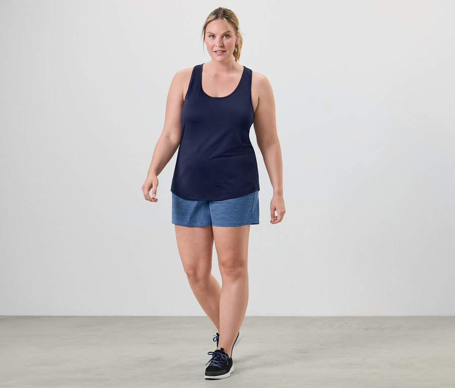 Frau geht und trägt einen der 2 Funktionstops, pink und blau.