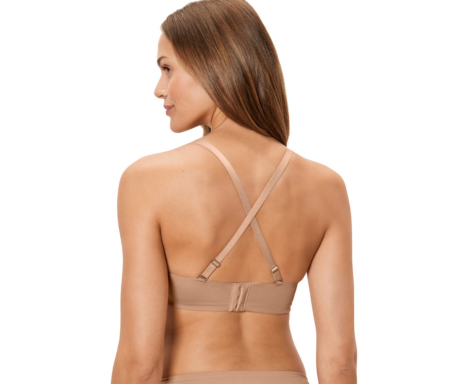 Rückansicht einer Frau, die einen hautfarbenen Multistyle-BH trägt, dessen Träger am Rücken gekreuzt sind.