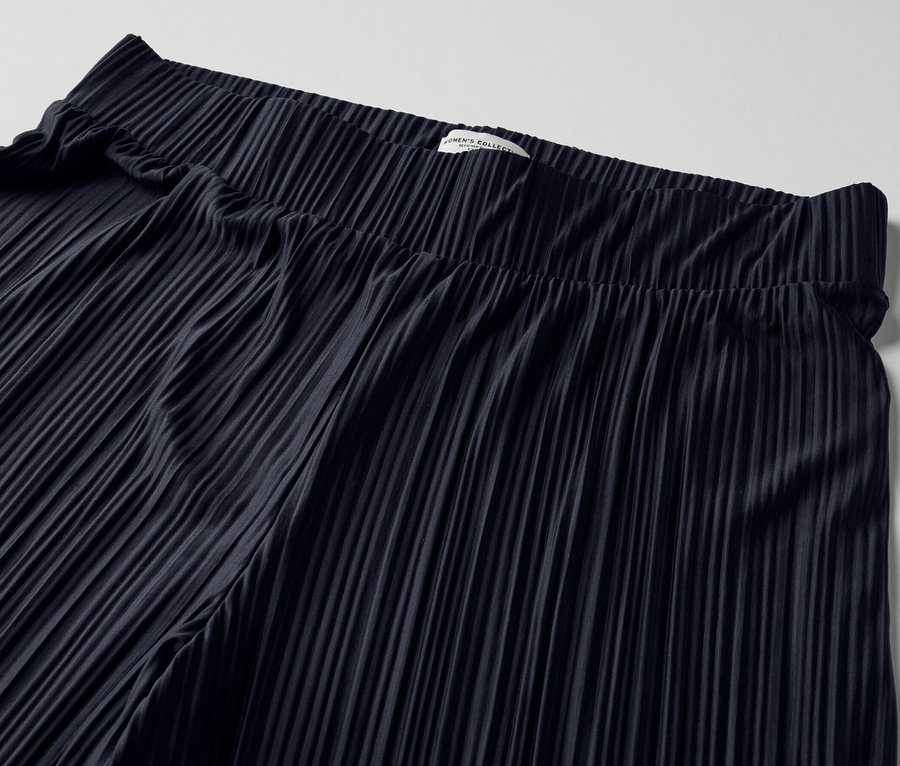 Detailaufnahme einer dunkelblauen Plisseehose.