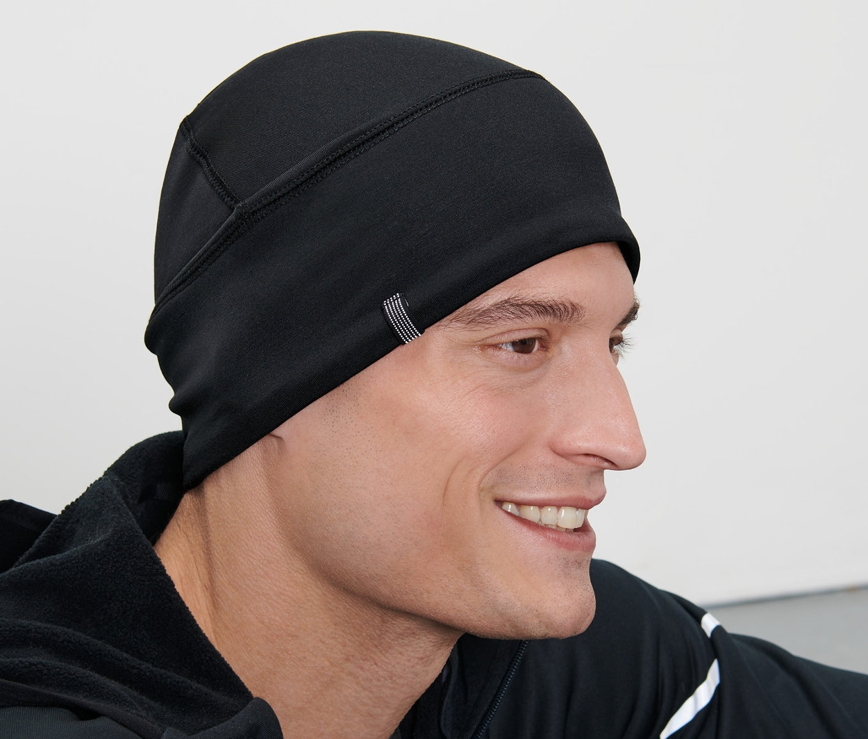 Mann trägt eine schwarze Thermomütze.