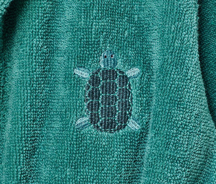 Detailansicht eines Kinder-Bademantels mit Schildkrötenstickerei.
