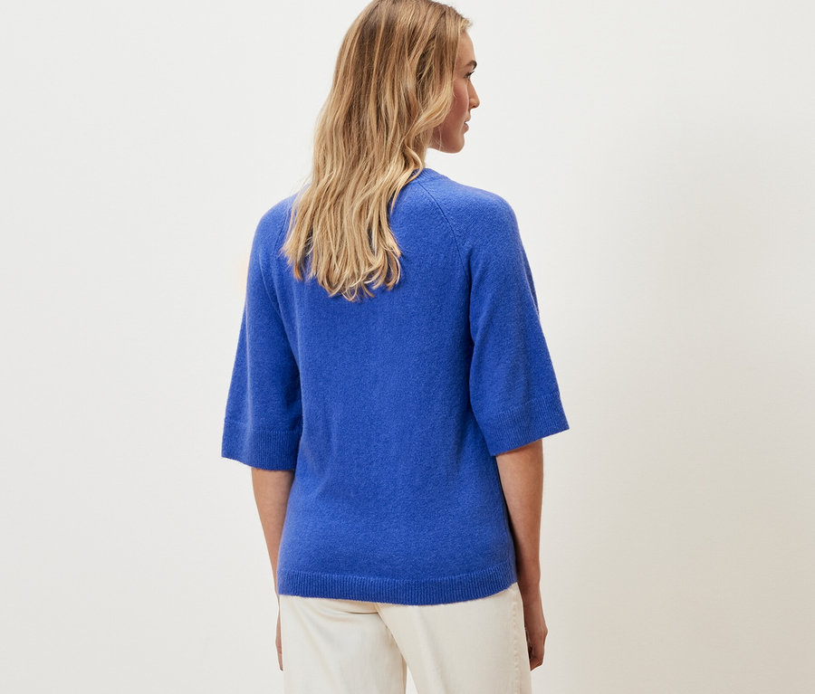 Frau trägt einen kobaltblauen Strickpullover.