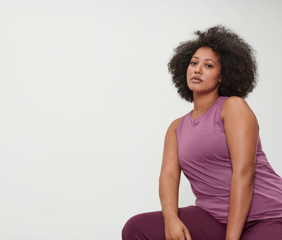 Frau trägt eine mauvefarbene 3/4-Yogahose und ein mauvefarbenes Sporttop.