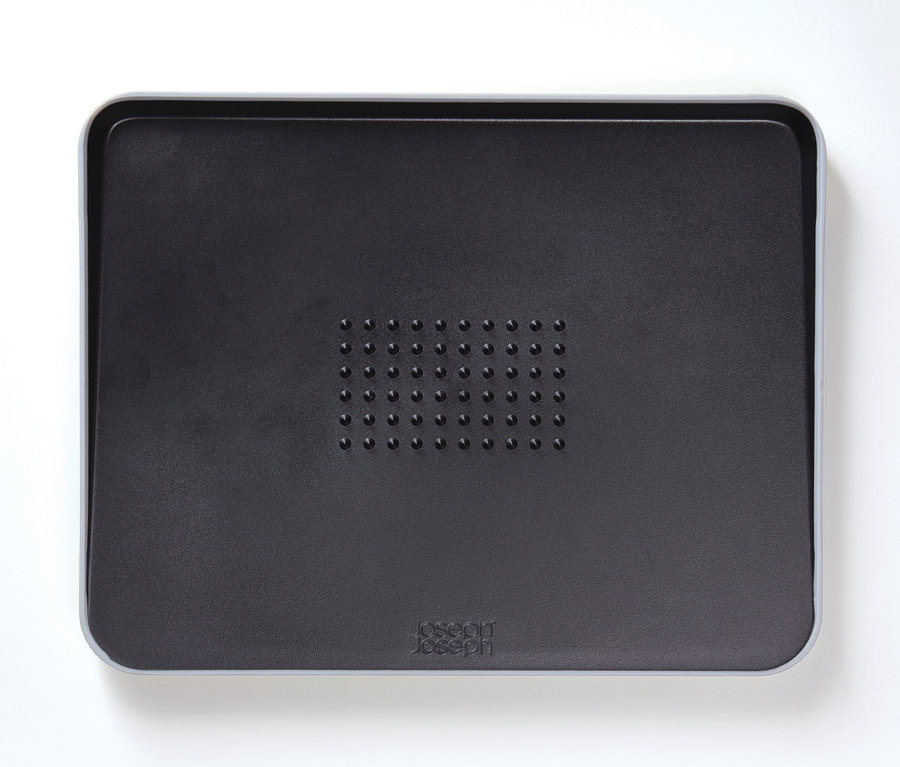 Schwarzes Joseph Joseph Cut and Carve Plus Schneidebrett auf weißem Hintergrund.
