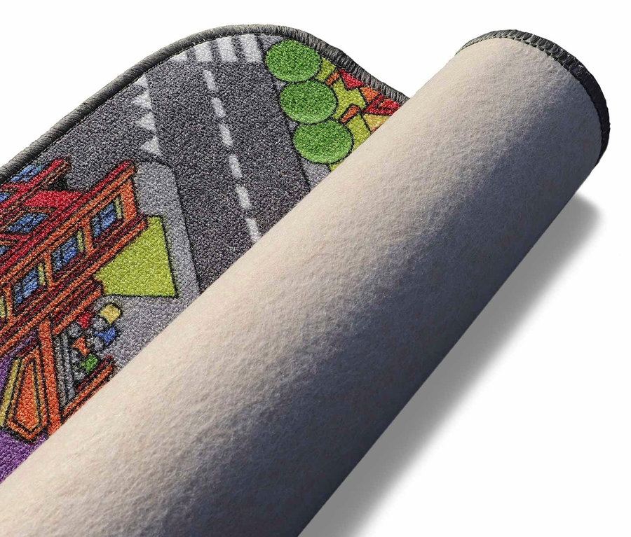 Ein teilweise aufgerollter Spielteppich »BIG CITY« mit Stadtmotiv.