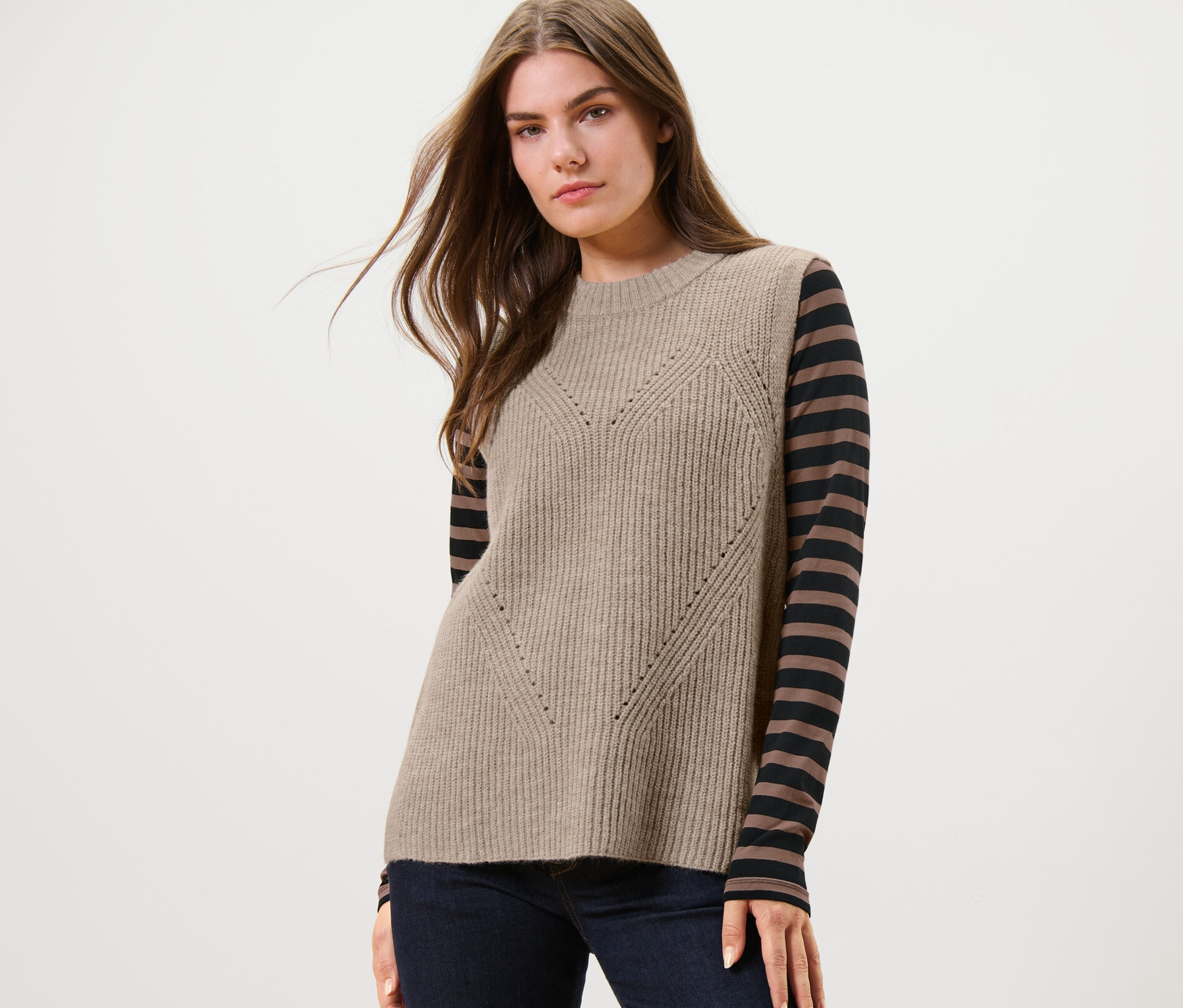 Frau trägt einen beige melierten Strick-Pullunder.