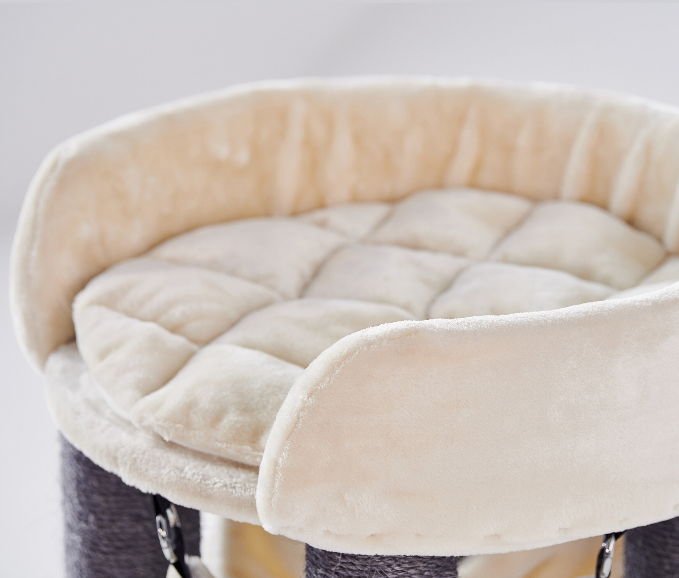 Detailaufnahme des oberen Teils des beigen Nobby ELA Kratzbaums mit gepolstertem Rand und gestepptem Kissen.