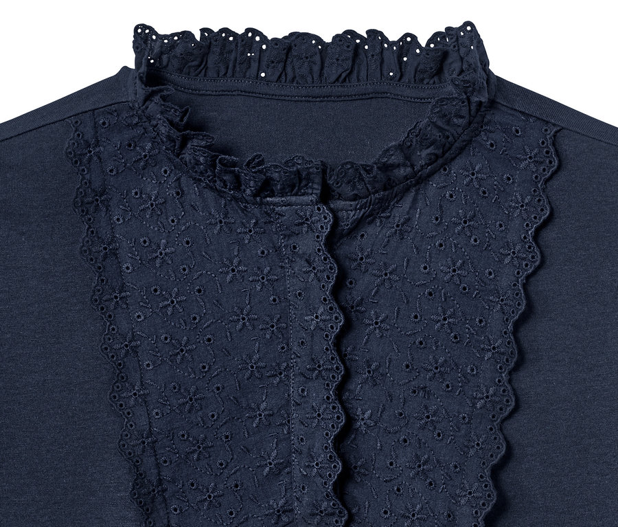 Detailansicht eines marineblauen Blusenshirts mit Lochstickerei.